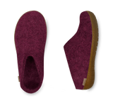 Pair of maroon slippers with brown soles on a white background